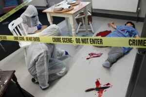 Students examining a fake crime scene