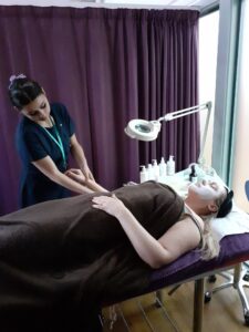 Beauty therapy student Mia Humphries gives Jo Anderson-Woodley, Customer Relations Manager at Bickerton House, a facial.