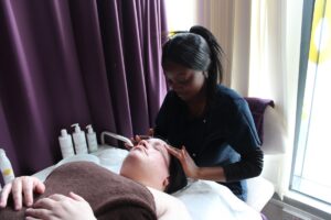 Beauty therapy student Flora Mugizi gives Bickerton House Care Worker, Frances a facial