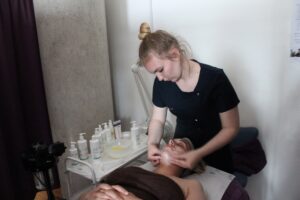 Beauty therapy student Kaitlyn Brighton gives a Bickerton House Care Worker, a facial