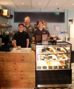 Foundation Pathways Cameron, Nic Lander, Founder & Director, The Kimel Foundation and Café assistant Rory stand behind the counter. 