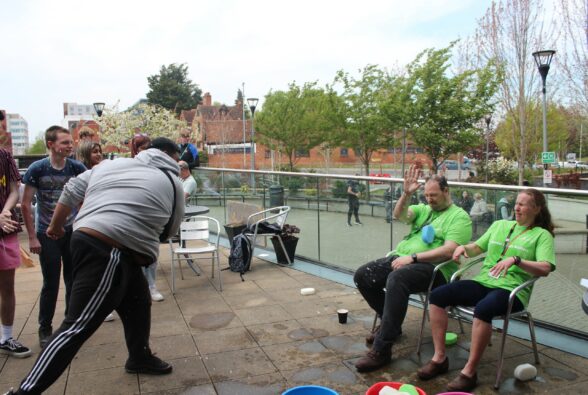 A learner throwing wet sponges at two members of staff