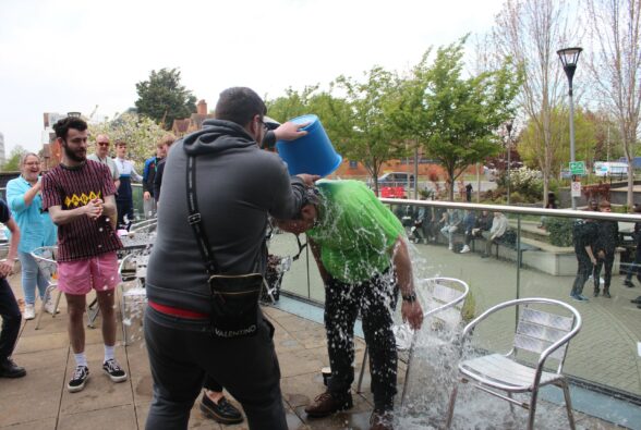 A learner throwing a bucket of water over a teacher's head