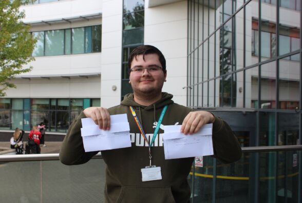 Aidan Leaning, Foundation Tier 4 student at Bracknell and Wokingham College holding his GCSE English and Maths results. 