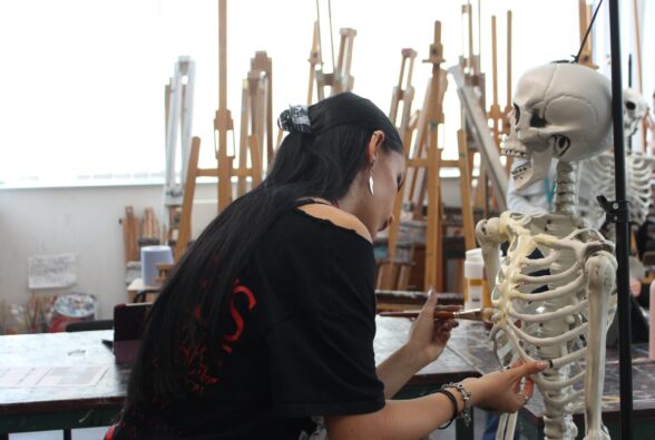 Art and Design student Bianka Humnicka painting one of the skeletons