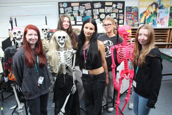 Group photo: Some of the Creative Practice: Art, Design and Communication Level 3 Diploma students with some of the skeletons. First row: Charlotte Dowse, Bianka Humnicka, and Susie Dowse. Second row: Caitlin Cameron-Mcfarlane and Cecile Poulain.