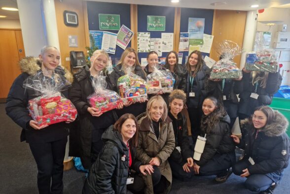 Group photo of Beauty Therapy Level 3 students and staff from Bracknell and Wokingham College with their parcels at Bracknell Foodbank.