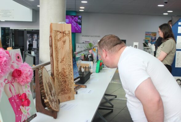 A member of the public looks at a pyrography piece of art on display at the exhibition.