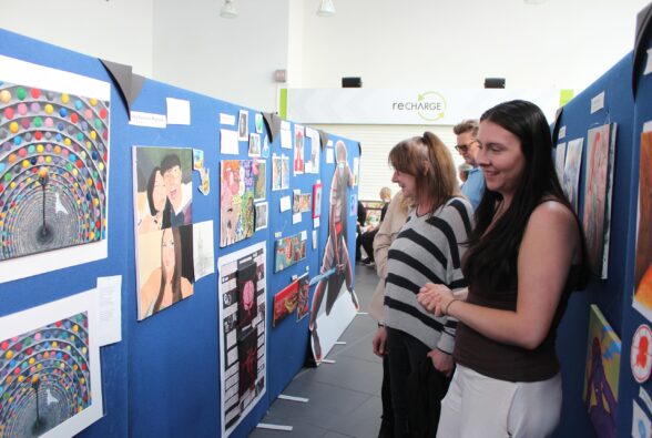 Two women look at the art on display at the exhibition.